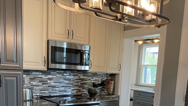 A modern kitchen with granite countertops, stainless steel appliances, and a central island.