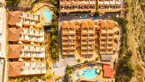 A resort with multiple swimming pools, sun loungers, and a central courtyard. - Wyndham Residences Costa Adeje (Adeje)