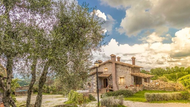 A stone house with a stone pathway leading to it, surrounded by greenery and trees. - Intimate independent room for couples (Soriano Nel Cimino)