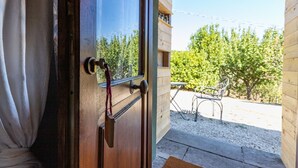A wooden door with a keyhole and a doorknob, leading to an outdoor patio with a table and chairs. - Intimate independent room for couples (Soriano Nel Cimino)
