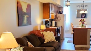 A living room with a sofa, a coffee table, a lamp, and a painting on the wall.