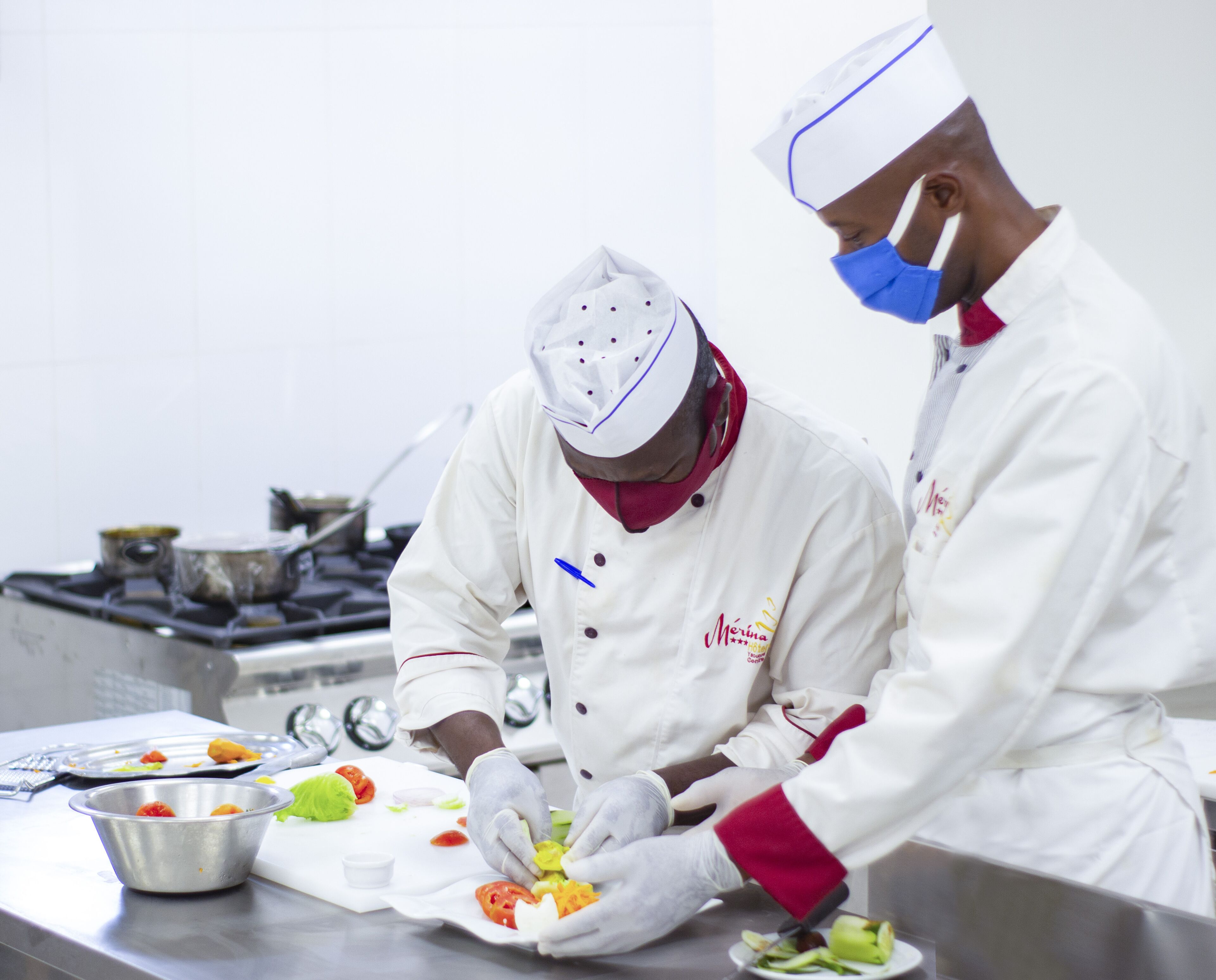 Two chefs preparing food in a professional kitchen.