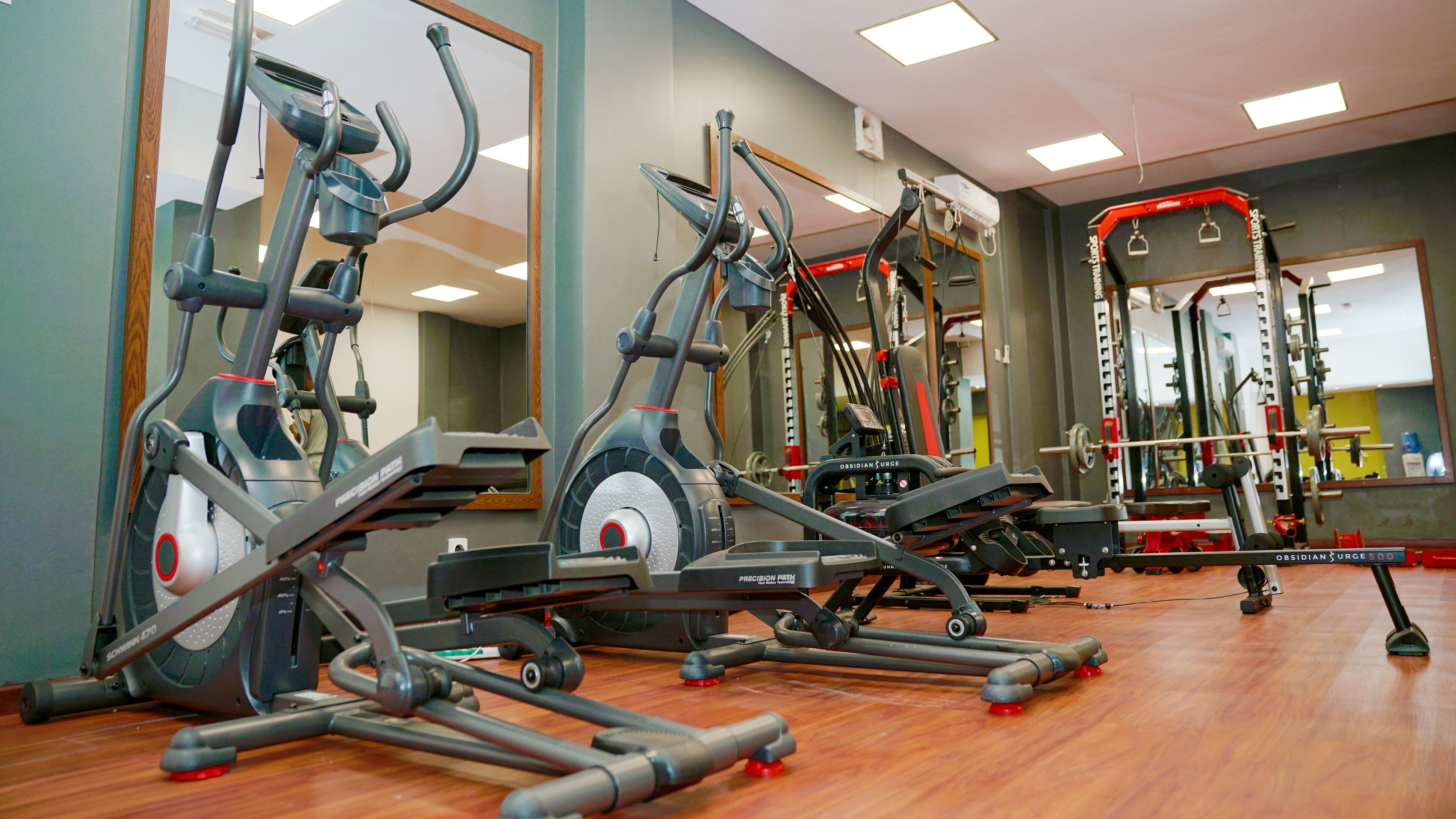 Uma academia com bicicletas ergométricas, esteiras e máquinas de musculação.