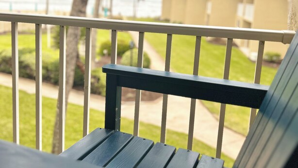 Un balcon avec vue sur l’océan et les palmiers.
