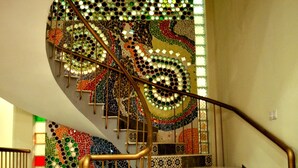 En trappe med mosaikudsmykket væg og gelændere.