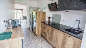 Una cocina moderna con armarios de madera, encimera negra y horno empotrado.