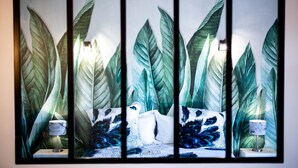 Una habitación con cama, dos mesitas de noche y una obra de arte grande en la pared.