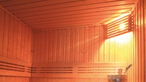 Una sauna con bancos de madera, una toalla y un balde.