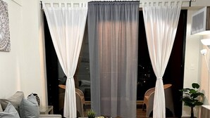 Una sala de estar moderna con un sofá, una mesa de centro y vistas al exterior de noche.