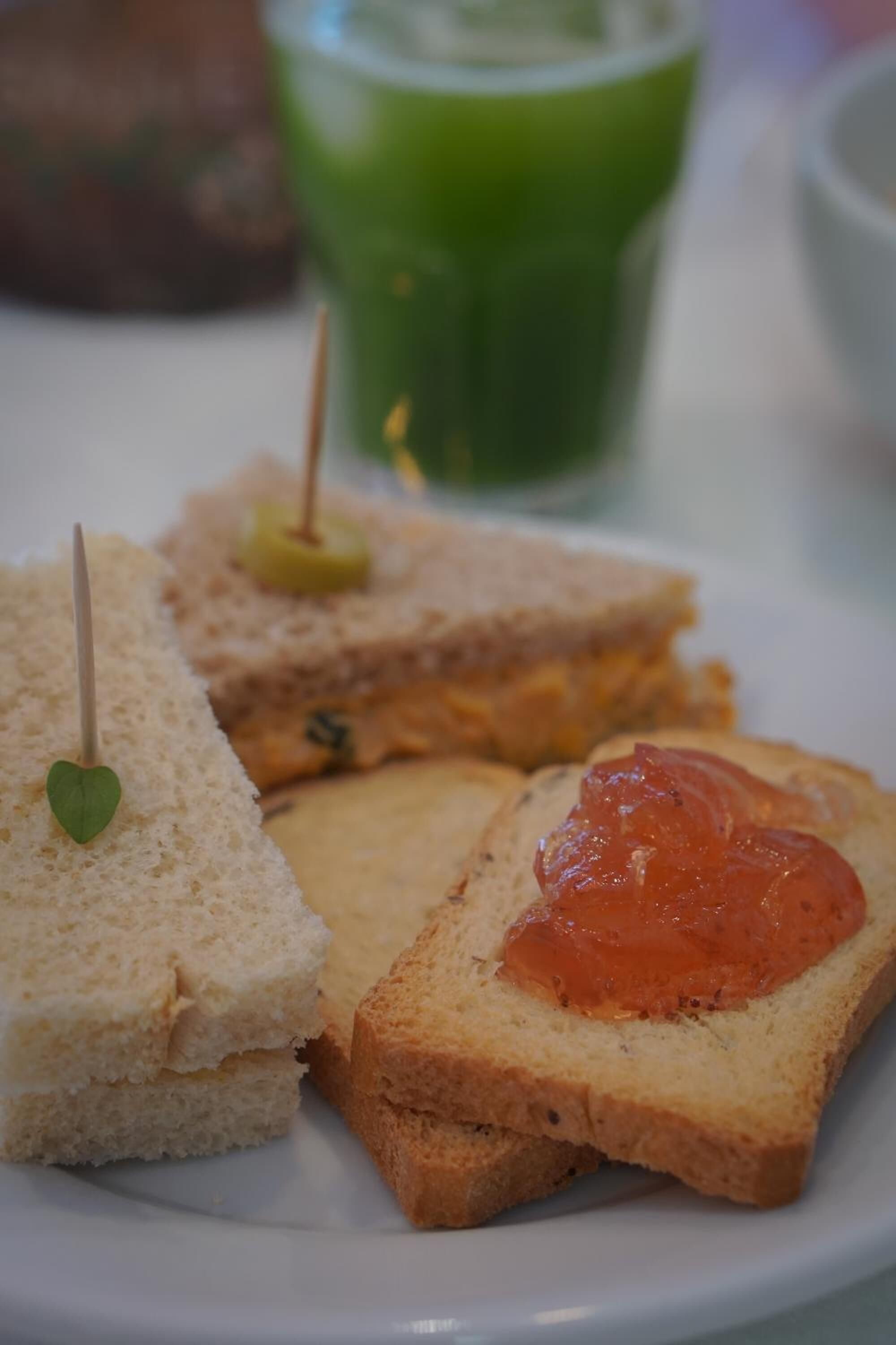 A plate with three sandwiches, each with a different topping.