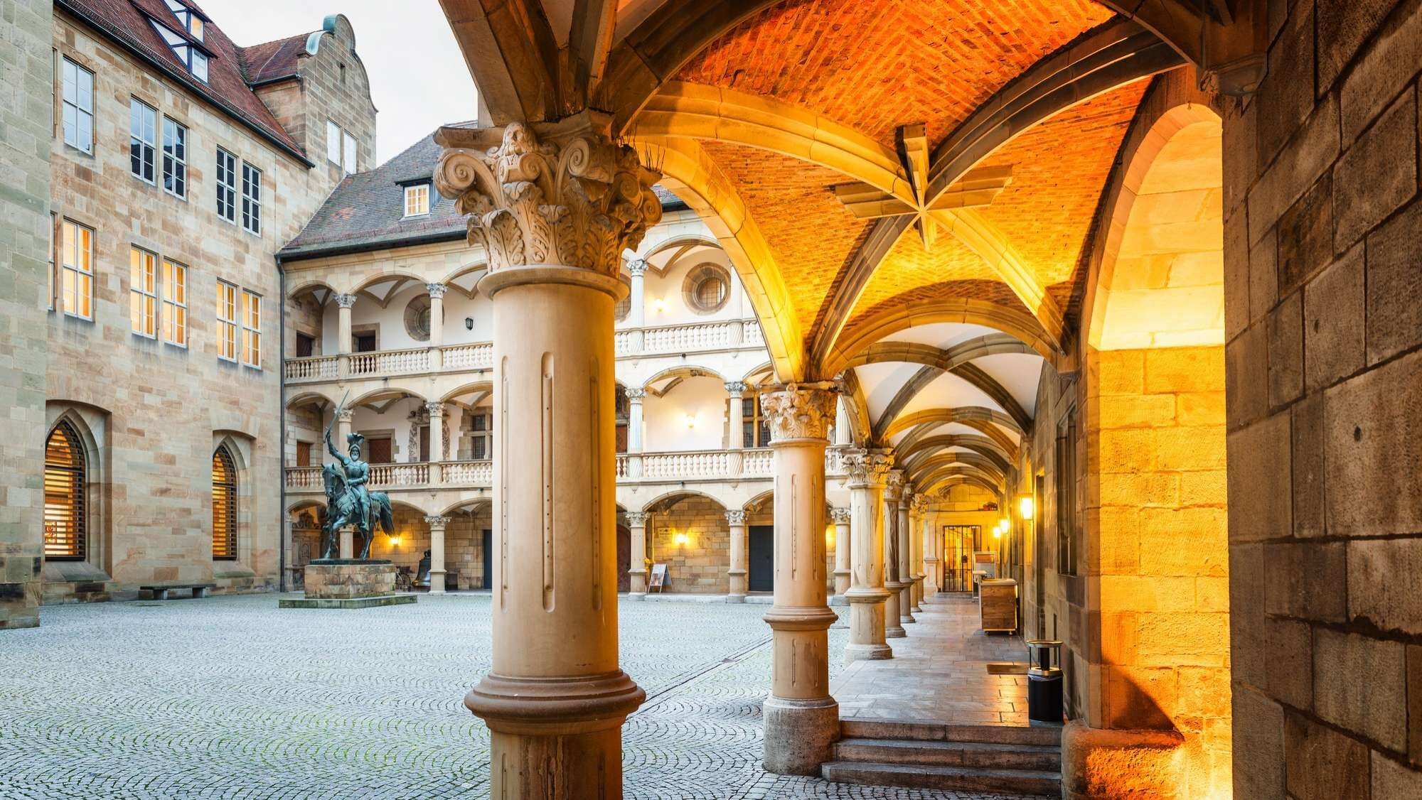 A historic building with a courtyard, arched ceilings, and classical columns.