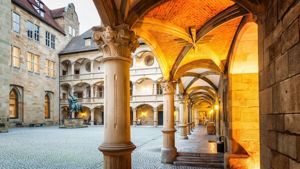 A historic building with a courtyard, arched ceilings, and classical columns. - Lo Exclusive Stuttgart – City apartment with terrace & garden (Stuttgart)