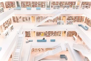 A multi-level library with bookshelves, seating areas, and staircases. - Lo Exclusive Stuttgart – City apartment with terrace & garden (Stuttgart)