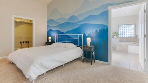 A bedroom with a bed, a nightstand, a wall mural, a closet, and a bathroom visible through an open door. - Spacious 1 Level Sisters Home - Walk to Downtown (Sisters)