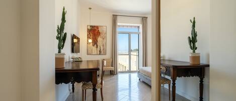 A spacious room with a large window, a dining area with a table and chairs, and a bed.