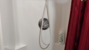 A shower with a handheld showerhead, a bottle of Dove body wash, and a red curtain. - Cozy 1 Room Cabin (Mountain View)