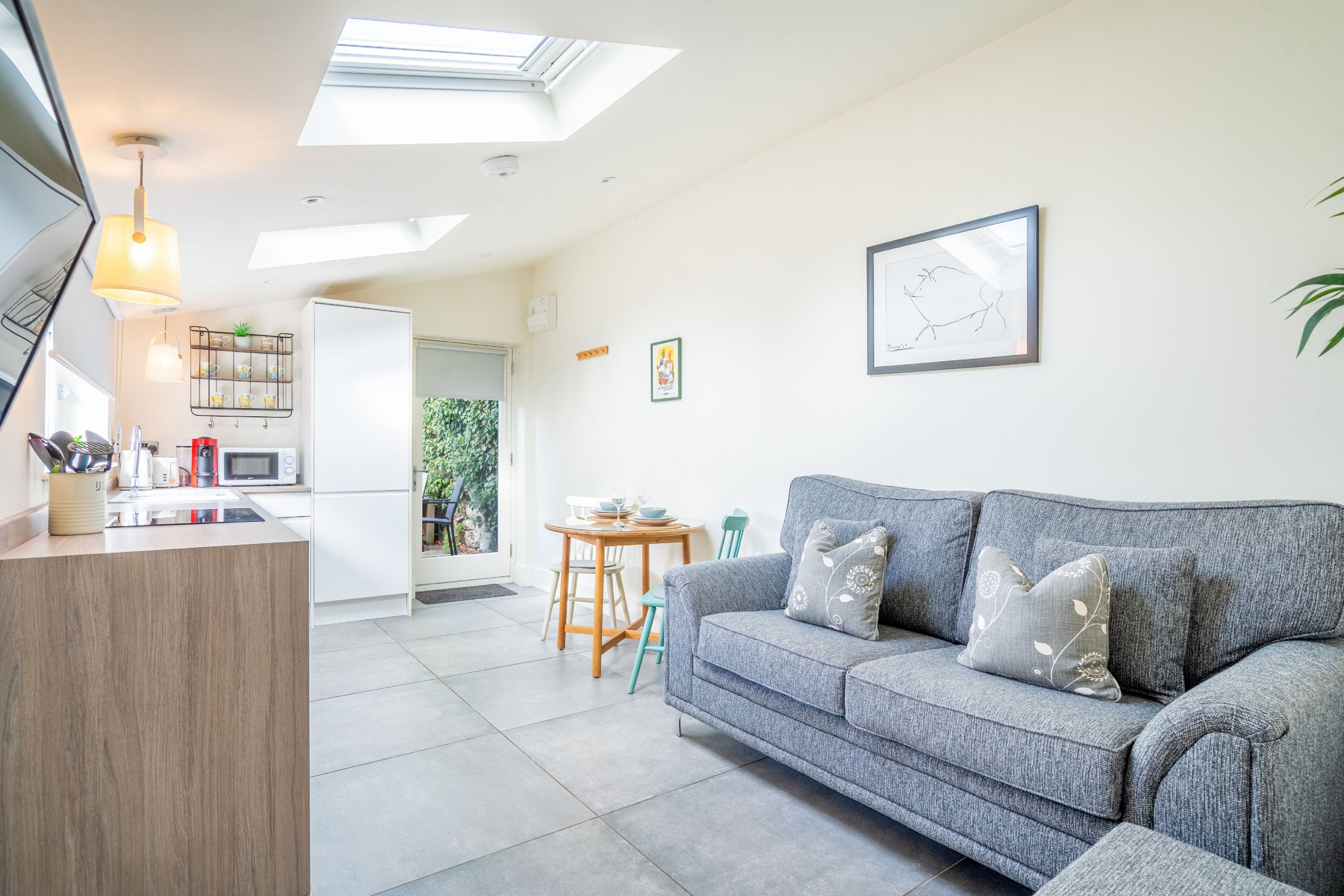 A modern living space with a kitchen, dining area, and a sofa.