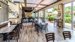 Ein Restaurant mit Holzboden, Tischen, Stühlen und einer Bar.