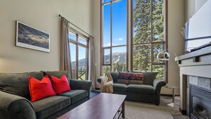 A living room with two sofas, a coffee table, and a fireplace. - Rare Ski In Ski Out Top Floor Corner Unit! (Sun Peaks)