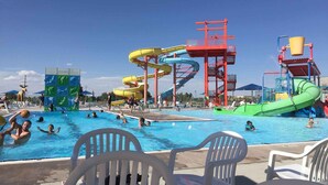 Um parque aquático com várias escorregas e uma piscina.
