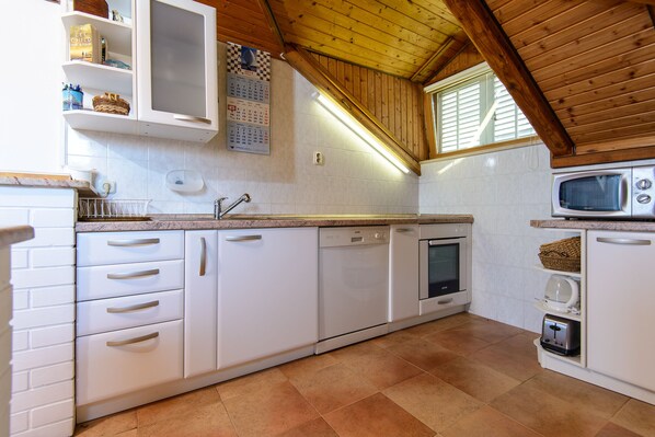 A kitchen with white cabinetry, a built-in dishwasher, a microwave, and a toaster. - 2-bed Apt, Sleeps 4 With Sea View, 5 min to Beach (Dubrovnik)