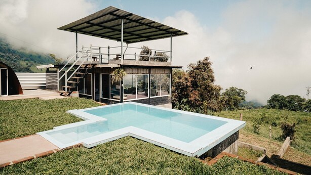 A modern house with a swimming pool, a covered outdoor area, and a view of the surrounding landscape. - Refugio Suncamal By Rotamundos (Cumanda)