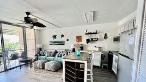 Eine moderne Küche mit Essbereich, Deckenventilator und Ausblick nach draußen.