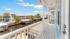 Ein Hotel am Wasserufer mit Balkon, Schwimmbad und mehreren Gebäuden.