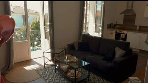 A living room with a sofa, coffee table, and a view of a balcony. - 2 beds 4 pers. 1,5km from Palais /swimming pool/parking 12min walk center Cannes (Cannes)