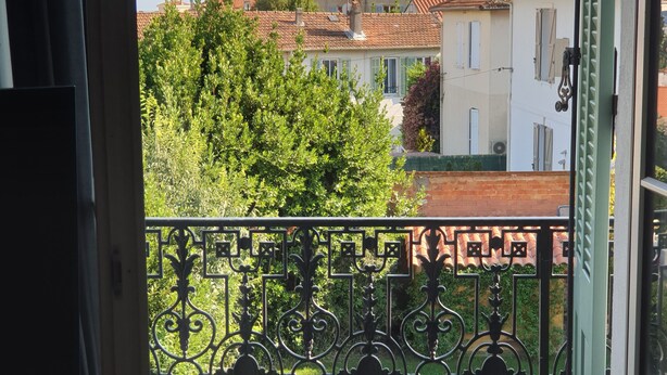 A balcony with a metal railing overlooking a swimming pool and a residential area with red-tiled roofs. - 2 beds 4 pers. 1,5km from Palais /swimming pool/parking 12min walk center Cannes (Cannes)