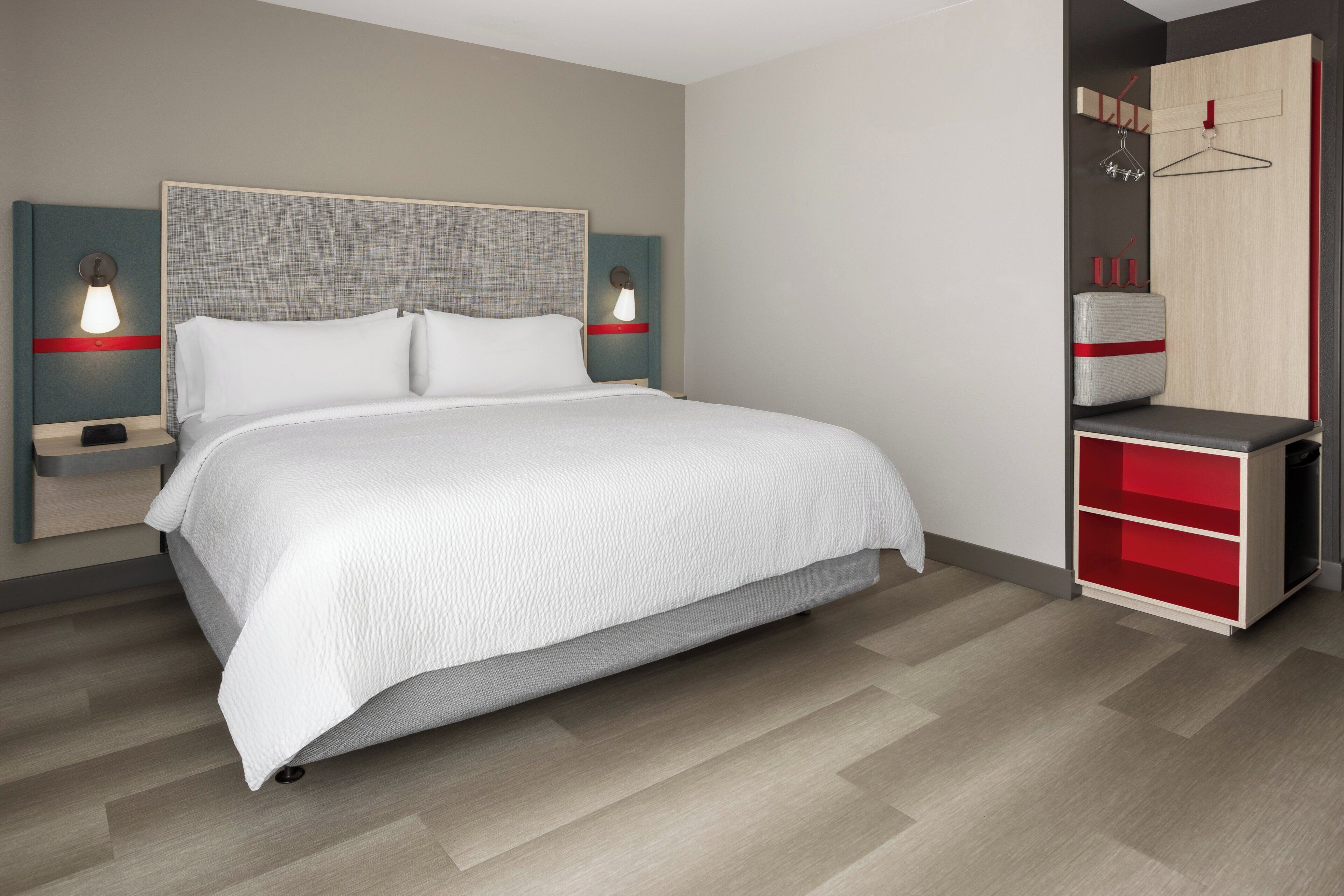 A bedroom with a bed, bedside tables, a wardrobe, and a mirror.