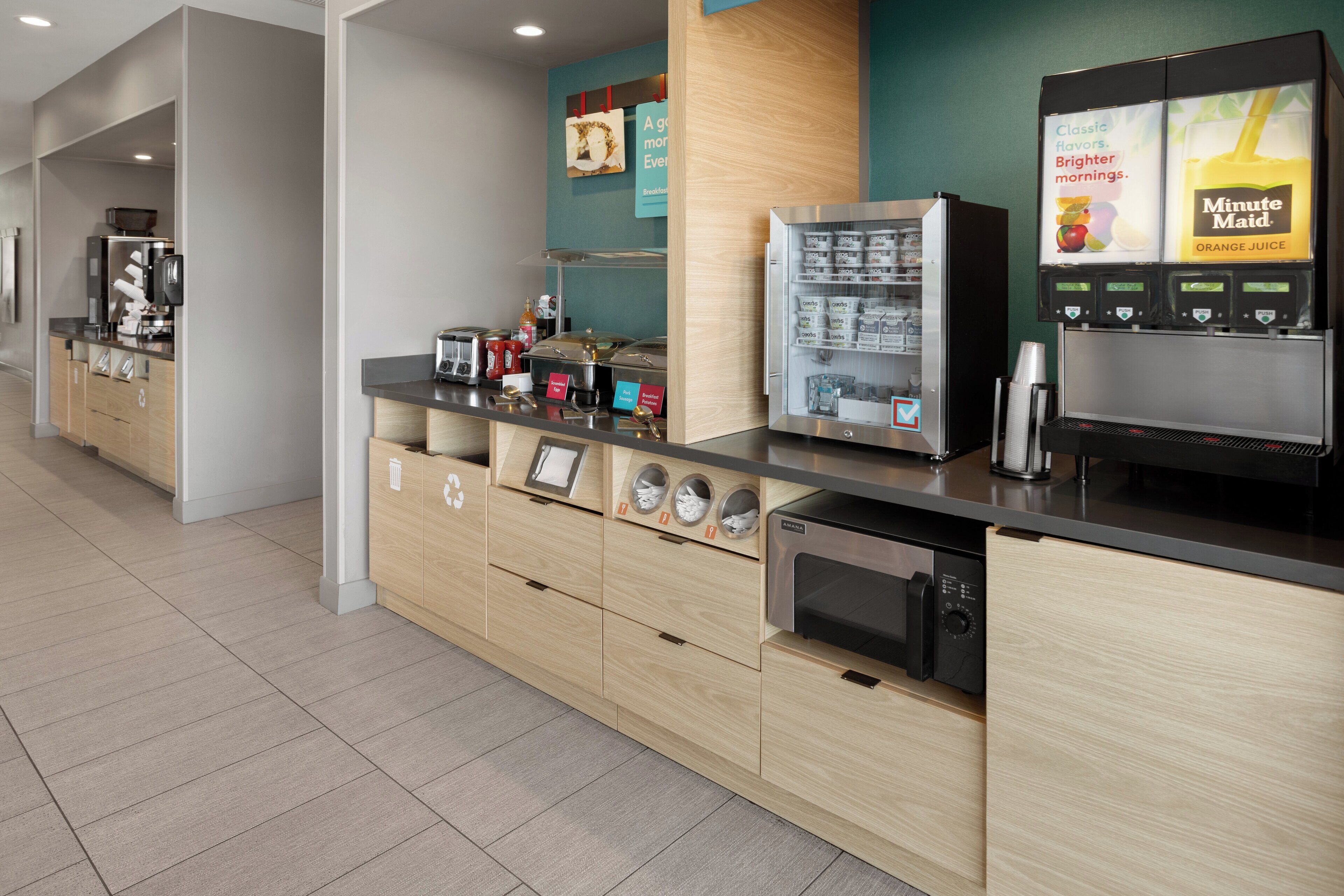 Un espace cuisine moderne équipé d’une machine à café, d’un réfrigérateur et d’un four à micro-ondes.