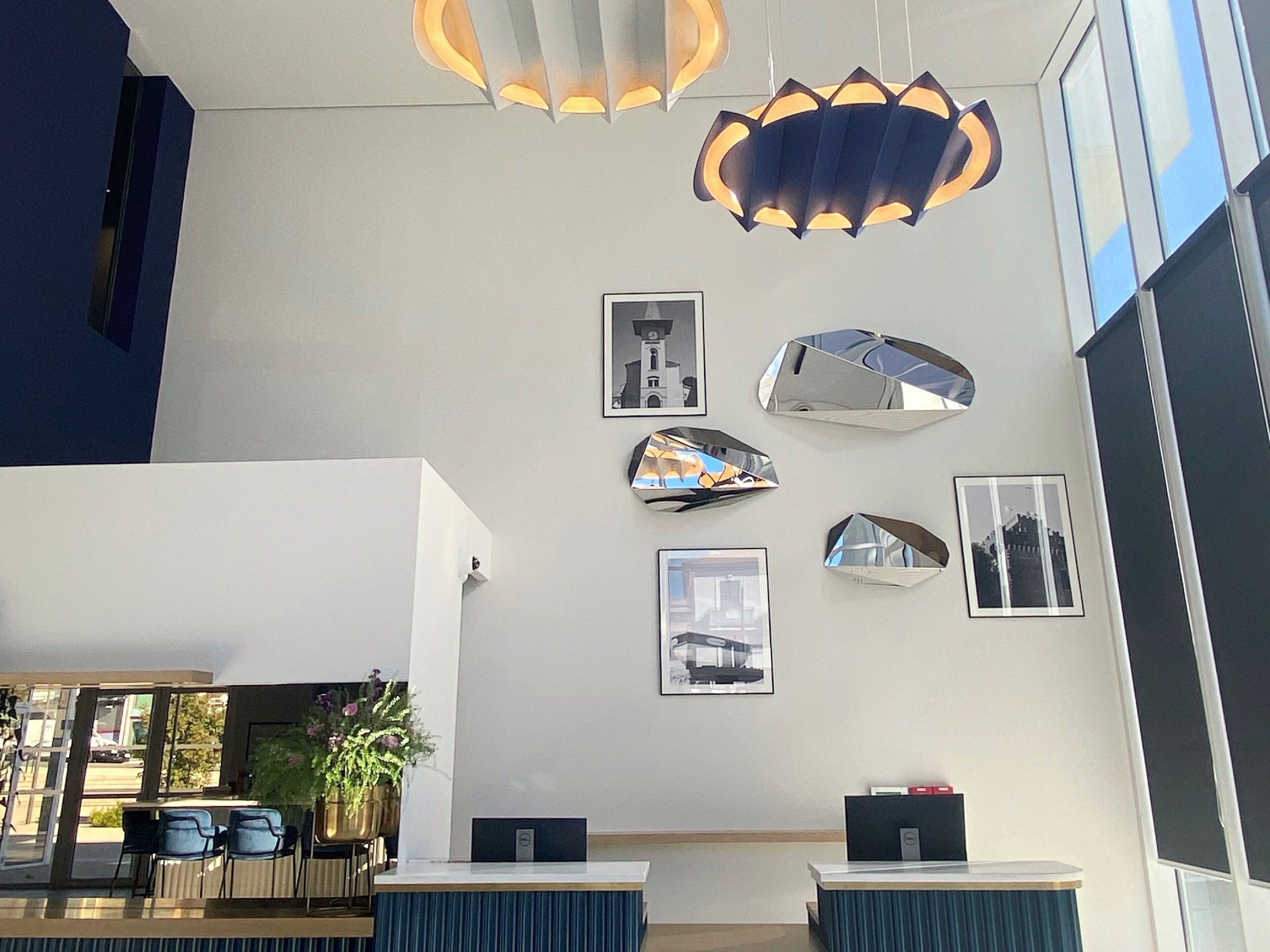 A modern reception area with a desk, chairs, and a large window.