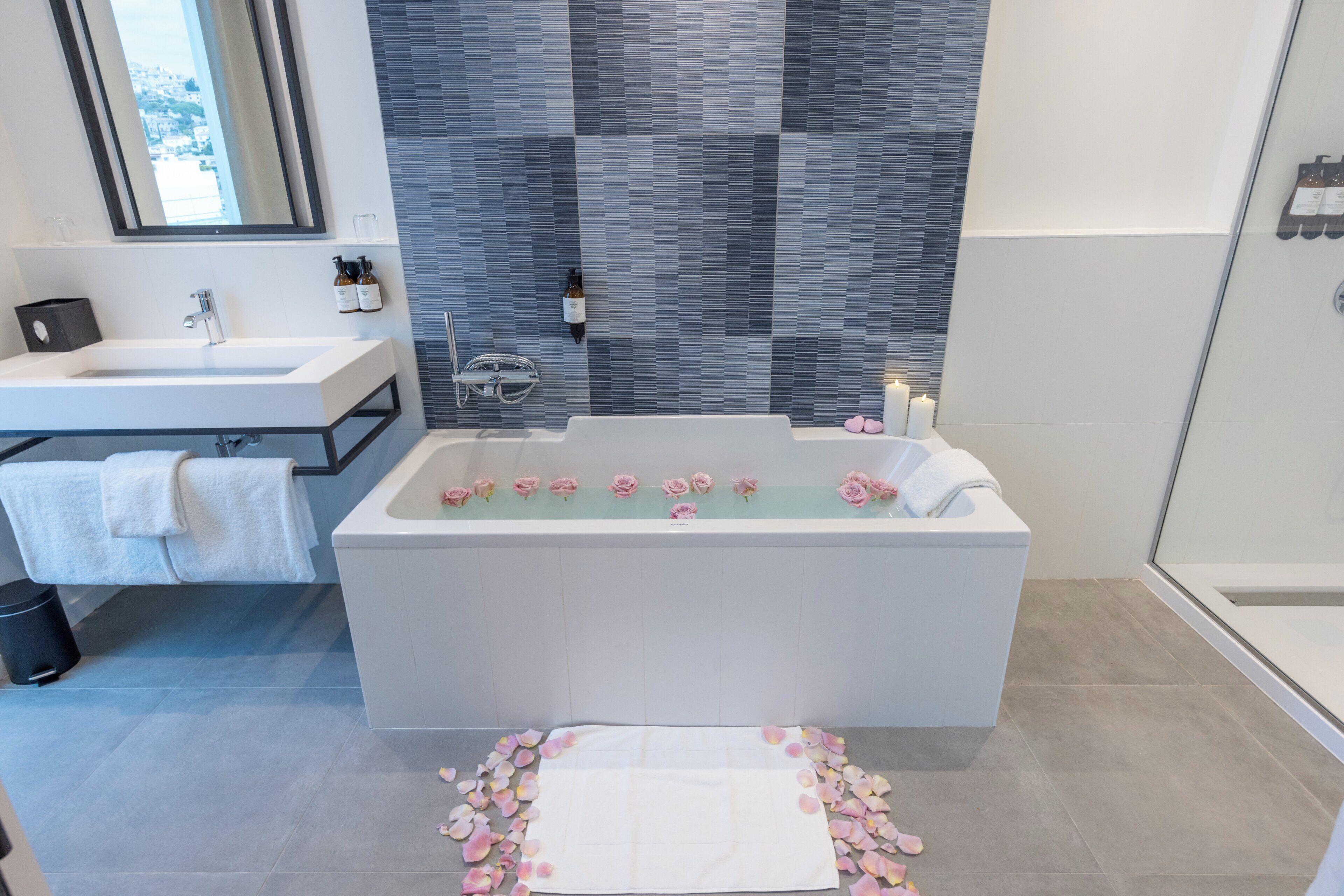 Un bagno moderno con una grande vasca, una doccia e un mobile lavabo con specchio.