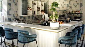 A modern bar area with a bar counter, seating, and a variety of bottles and glasses. - Hotel Indigo Cagnes-sur-Mer by IHG (Cagnes-sur-Mer)