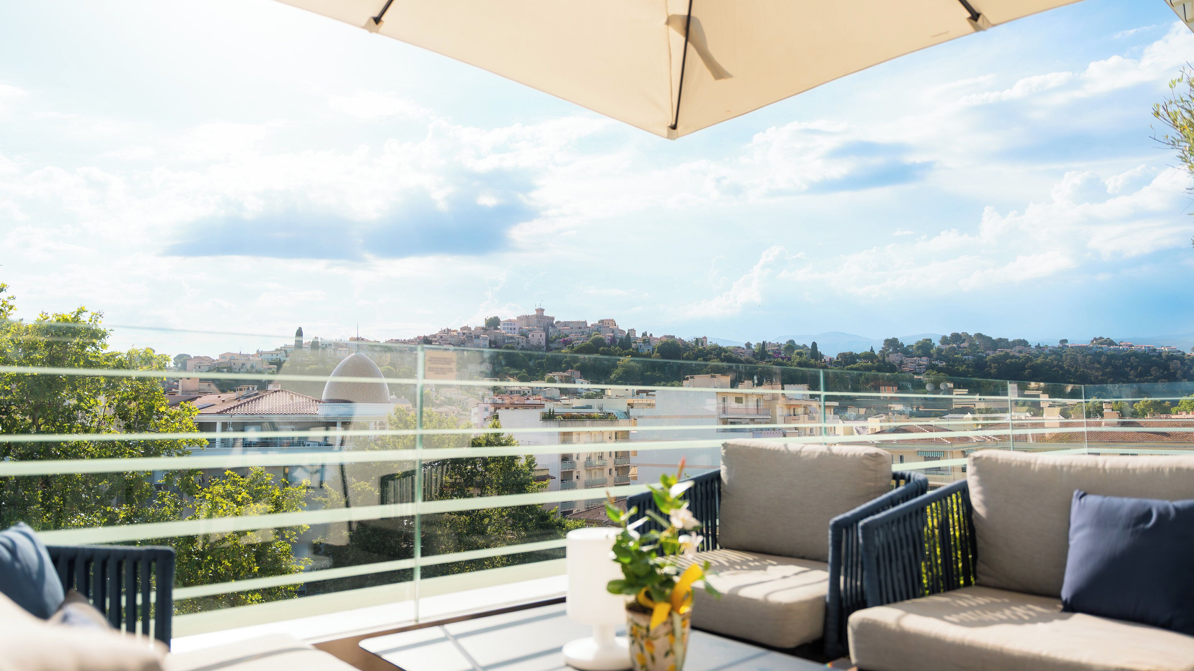 A balcony with a view of a cityscape, including a hill with buildings and a dome structure.