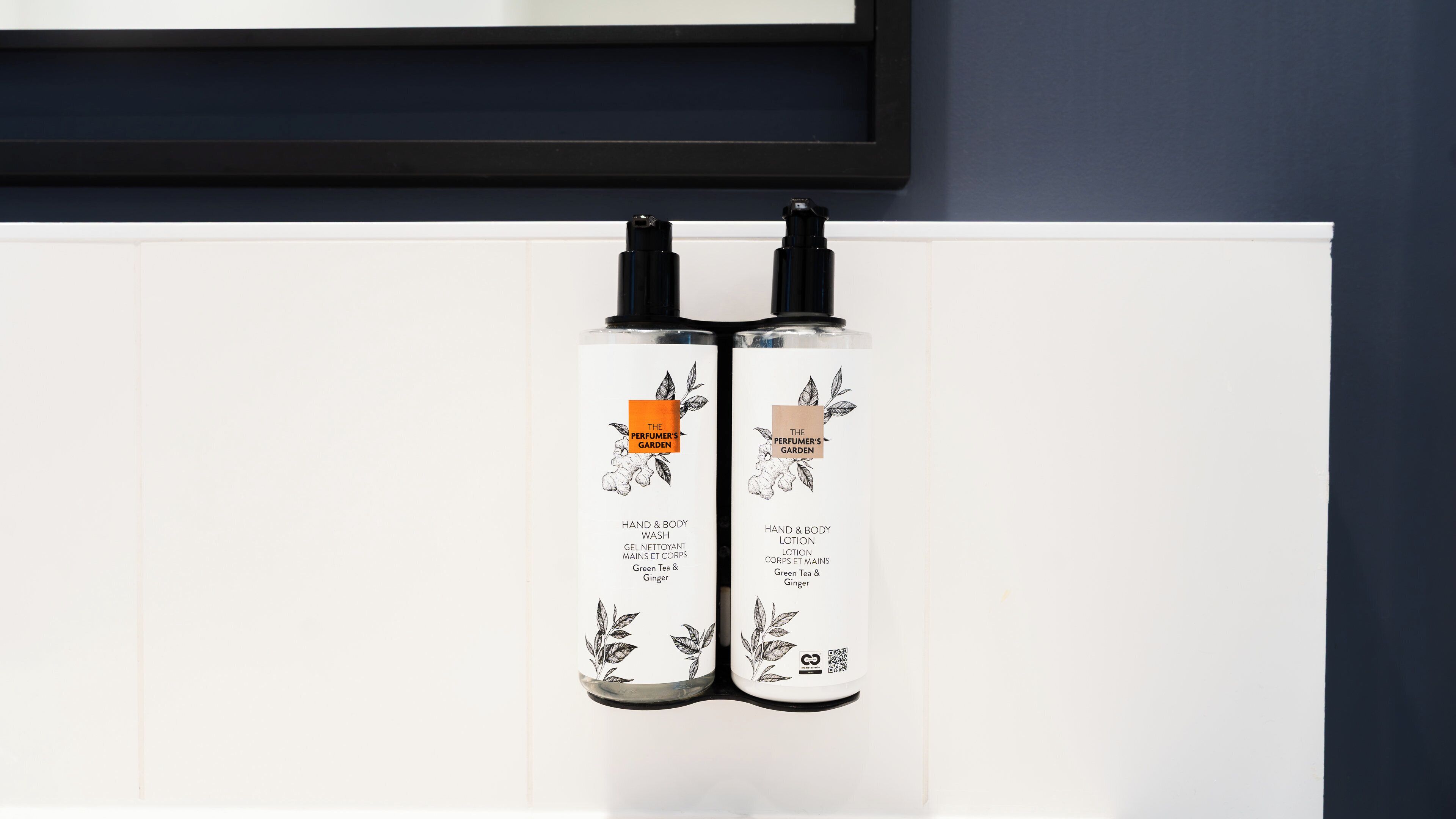 Two bottles of hand and body wash and lotion with a label that includes a QR code.