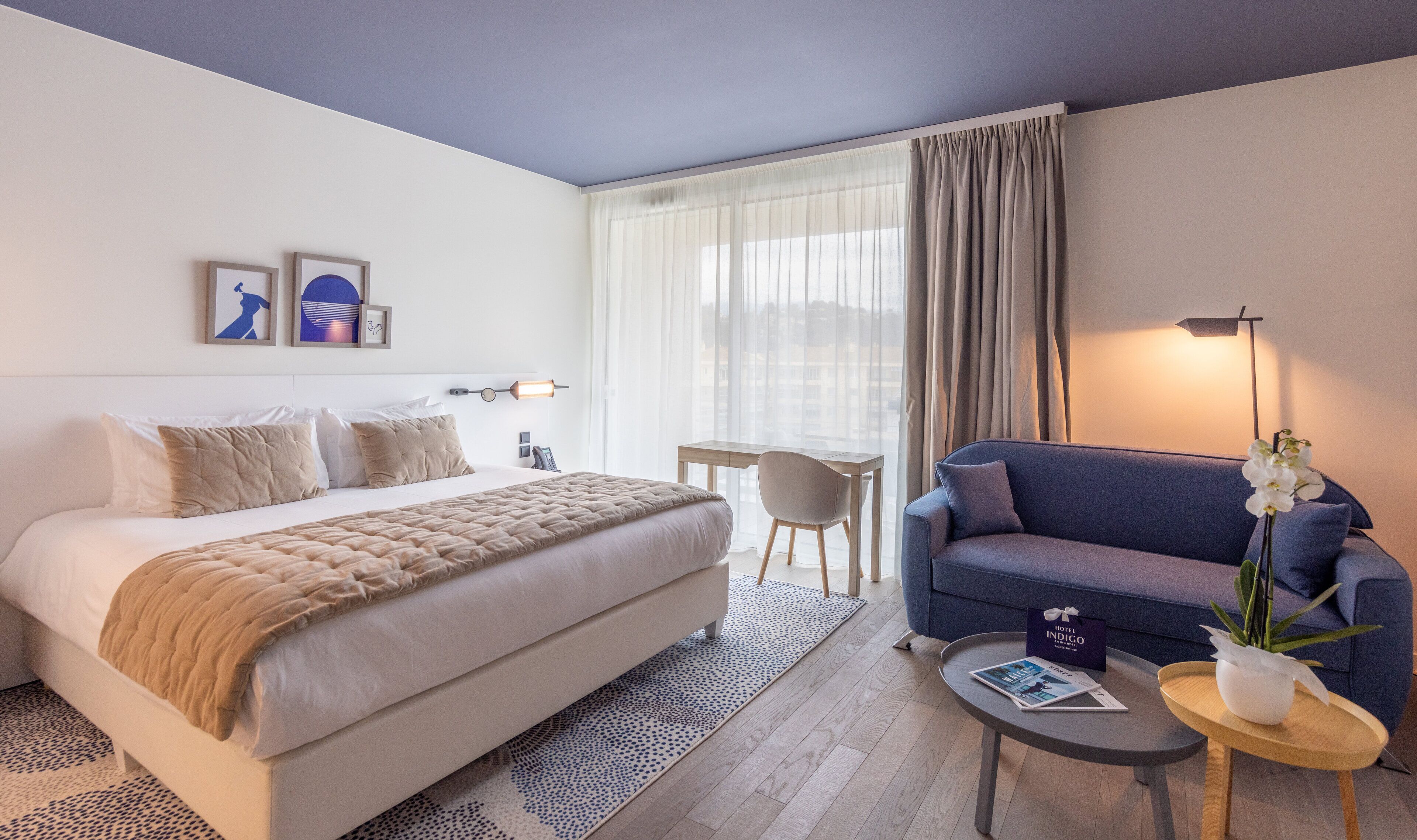 Une chambre d’hôtel avec un lit, un canapé, un bureau et une chaise.