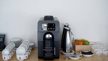Una máquina de café con pantalla digital, depósito de agua y jarra.