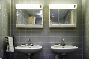 Casa de banho com duas pias, cada uma com espelho em cima.