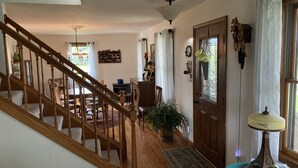 A staircase leading to a dining area with wooden flooring and a chandelier.