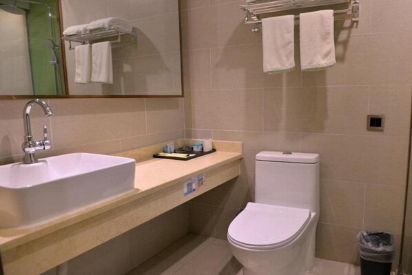 Un baño con lavamanos, inodoro y perchero para toallas.