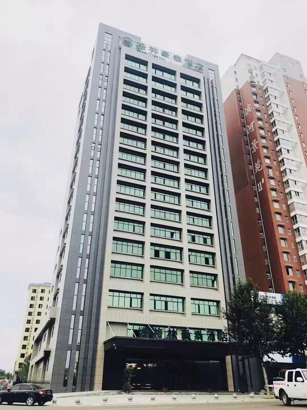 A high-rise building with multiple floors, featuring a series of windows and a covered entrance area. - Greentree Inn Luoyang Ruyang County Dujuan Avenue Hotel (Luoyang)