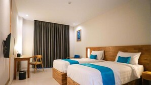 A hotel room with two wooden beds, a desk, a chair, and a large window with curtains. - Pollos Hotel & Gallery Rembang (Rembang)