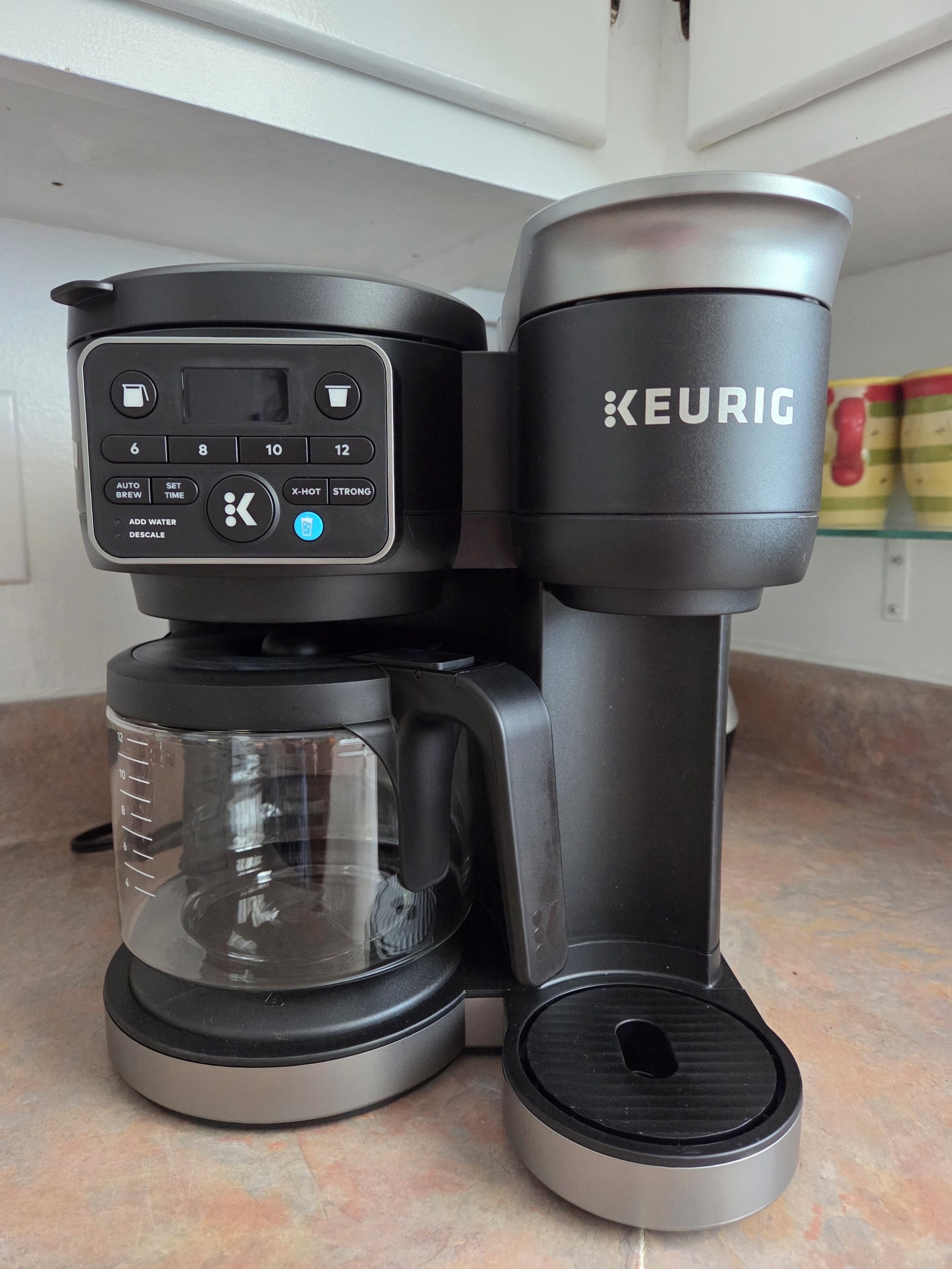 Een koffiezetapparaat met een digitaal bedieningspaneel en een waterreservoir.
