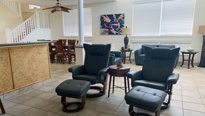 A spacious living room with a high ceiling, a staircase, and a dining area. - Stunning ocean view Ali'i Cove J-1 (Kailua Kona)
