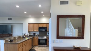 A modern kitchen with wooden cabinets, a built-in oven, and a microwave. - Stunning ocean view Ali'i Cove J-1 (Kailua Kona)