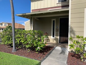 Welcome to this charming home with a beautifully landscaped yard and a pathway leading to the front door.