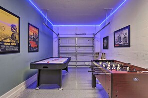 A room with a foosball table, pool table, and two posters on the walls. - Fantastic 2 KING bed EnSuite Villa w heated pool HOT TUB Mins to Disney (Kissimmee)