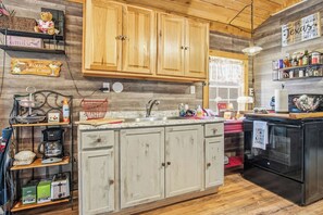 Une cuisine avec des meubles en bois, une machine à café et un réfrigérateur.